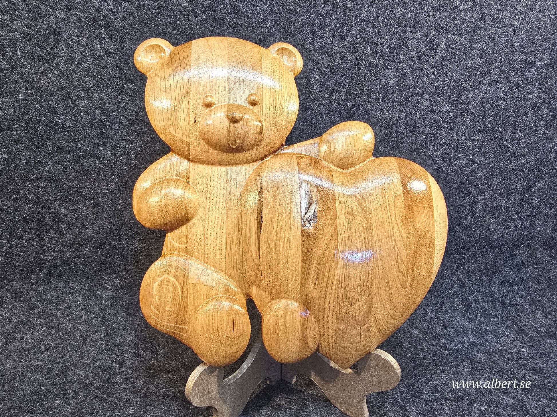 Skulptural nallebjörn i ekträ som tillfällig gravvård, personligt hantverk för en vacker minnesplats.