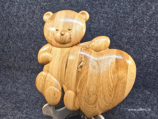 Handgjord gravmarkör formad som en nalle i massiv ek med ett hjärta och glansig finish från Alberi.