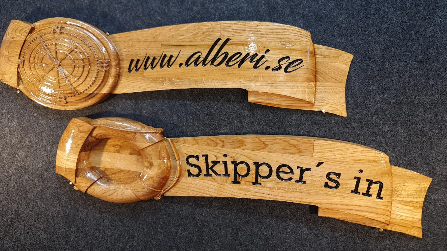 Personlig namnskylt i trä med svartmålad gravyr och handmålade detaljer för ett unikt uttryck på båten.