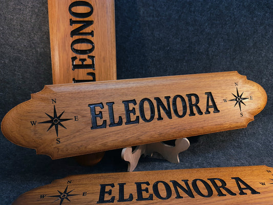 Handgjord namnskylt i massiv mahogny med personlig gravyr  och kompassrosor för båt eller husvagn.