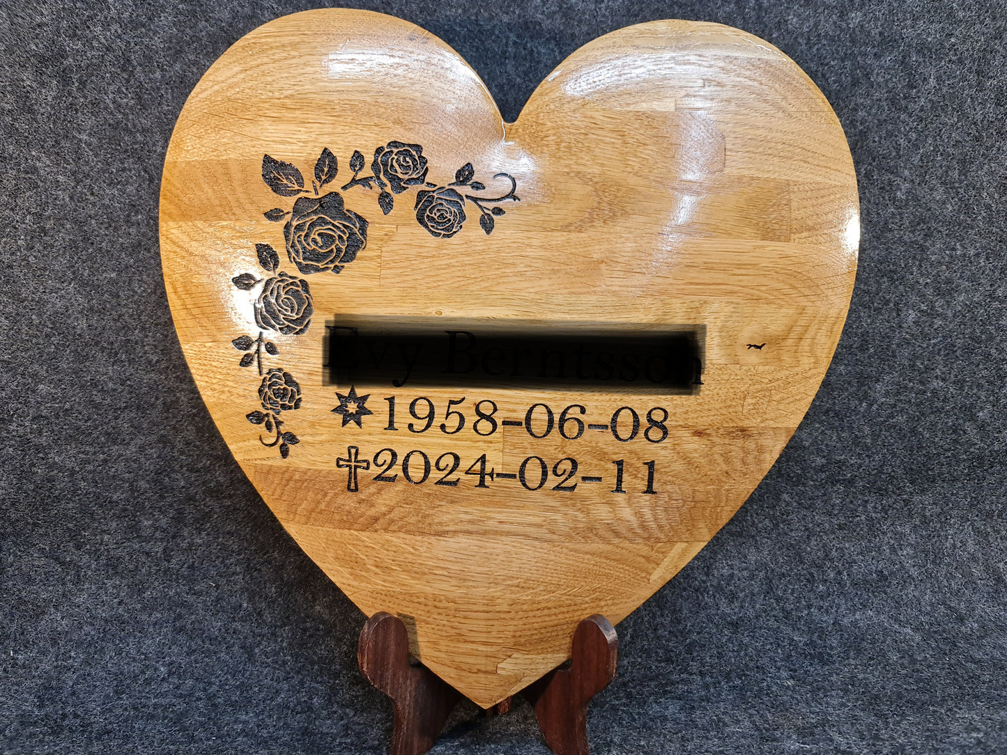 Hjärtformad minnesmarkör i ädelträ med kundanpassade symboler och text för en värdig minnesplats.