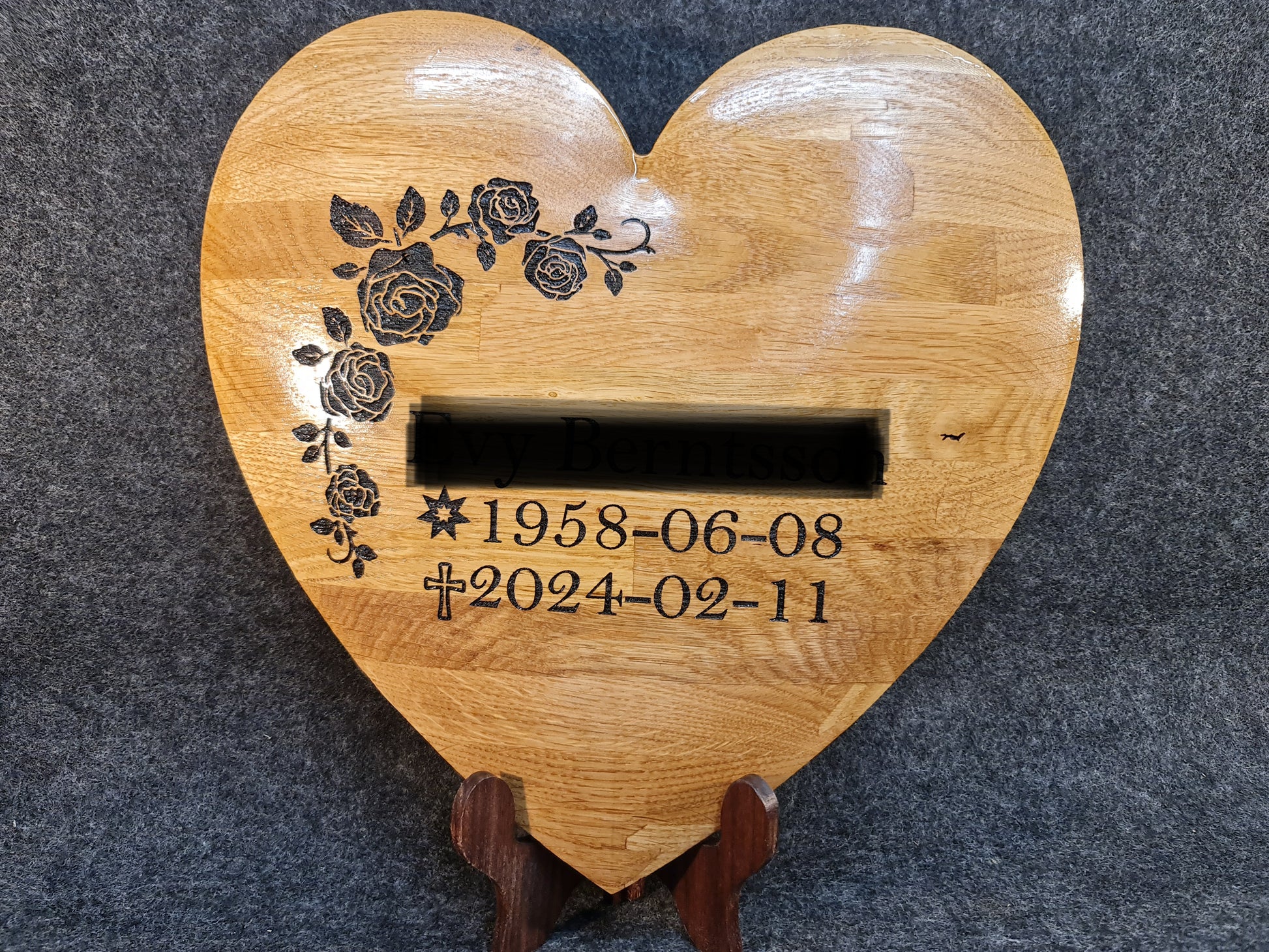 Hjärtformad minnesmarkör i ädelträ med kundanpassade symboler och text för en värdig minnesplats.