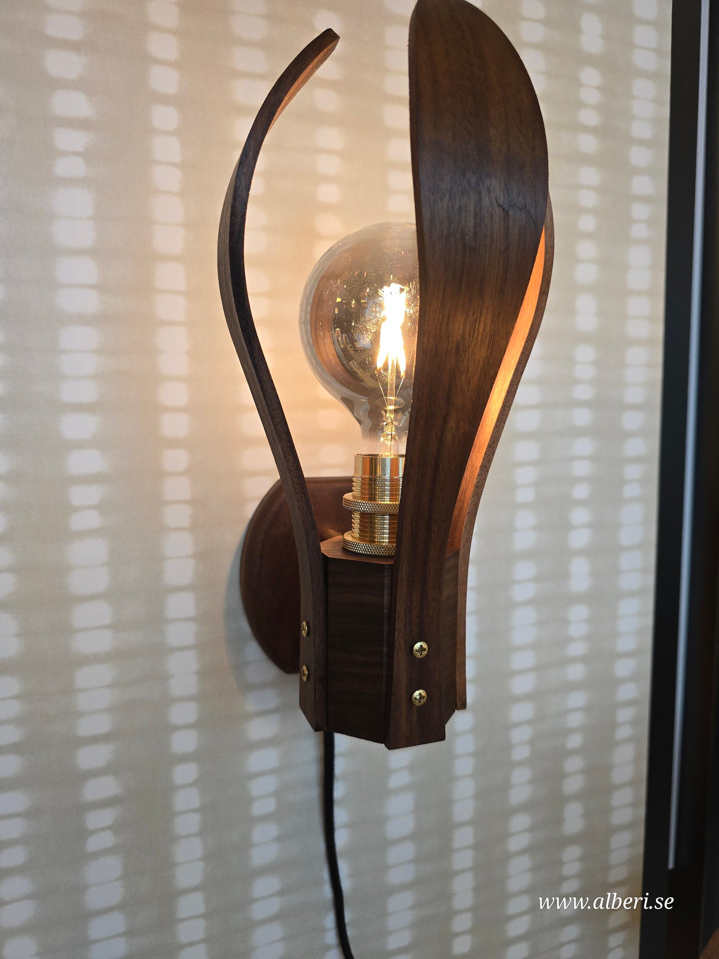 Väggmonterad trälampa Droppen som ger en stämningsfull belysning i skandinavisk design.