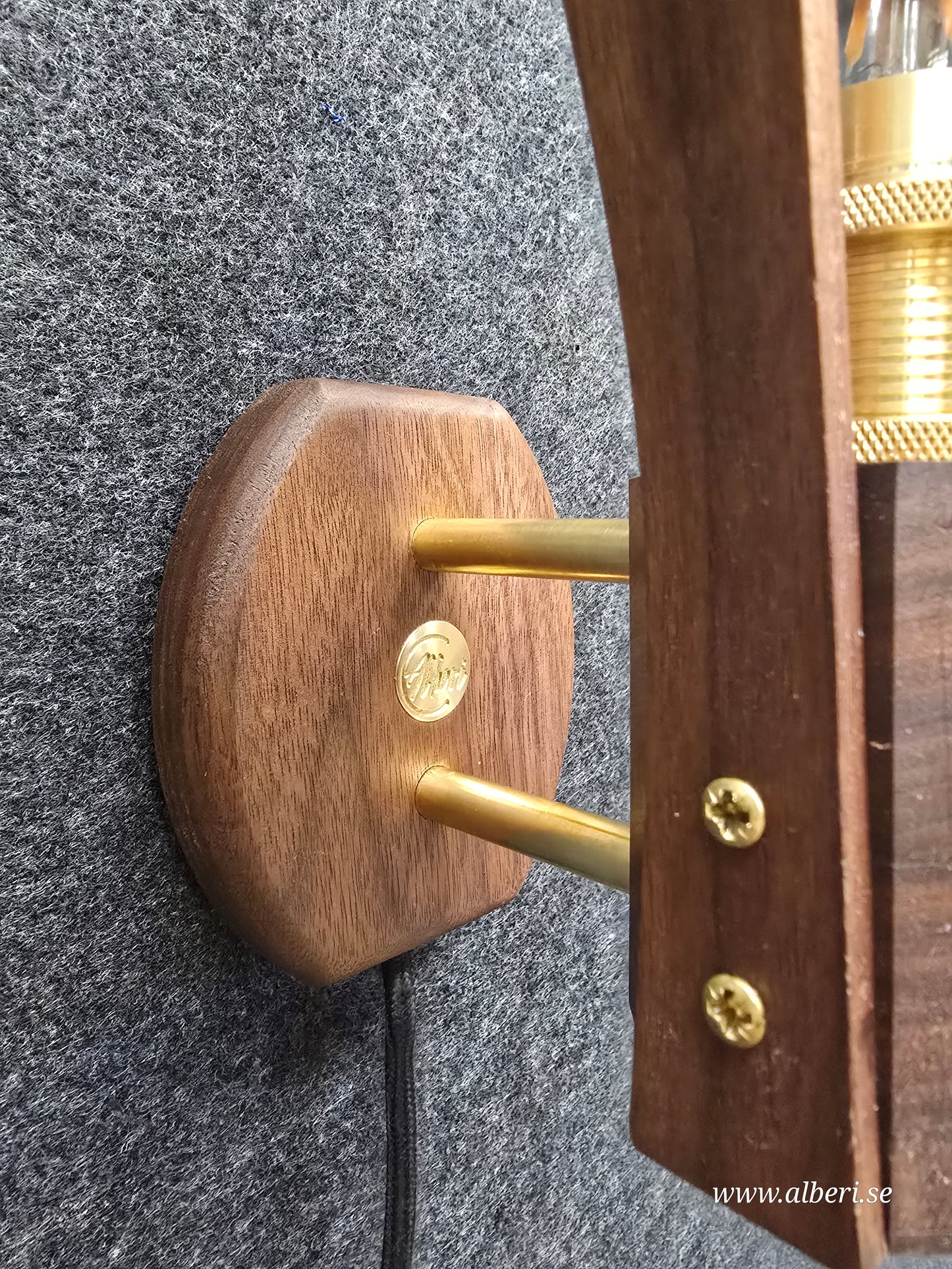 Närbild på fäste i äkta mässing och detaljer i massivt valnötsträ på en vägglampa.