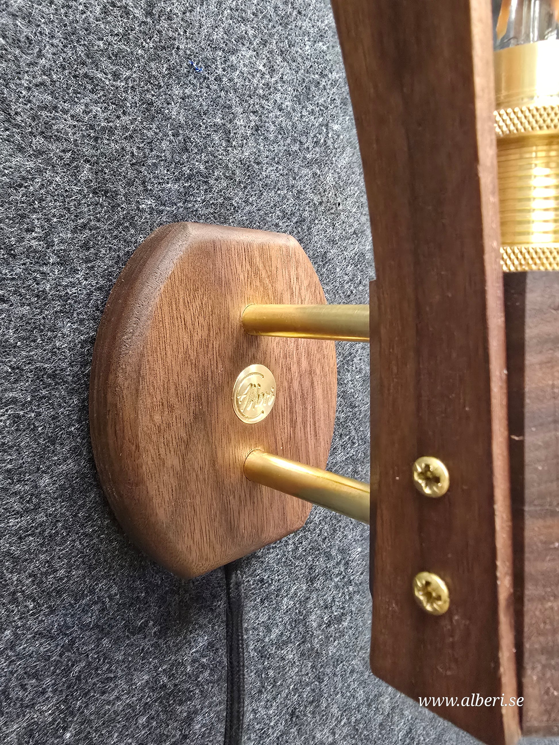 Närbild på fäste i äkta mässing och detaljer i massivt valnötsträ på en vägglampa.